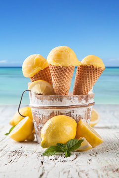 Lemon cce cream scoops in cones with blur beach