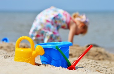 Little girl playing on the sand beach