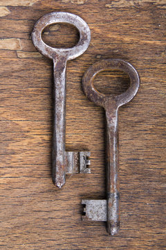 two rusty keys on wooden background