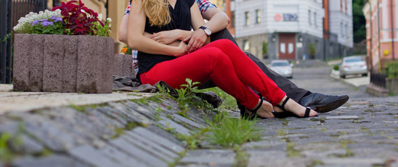 Love couple sitting on the pavement