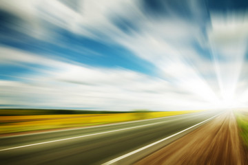 Road through the yellow sunflower field