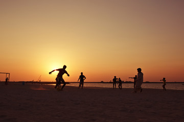 Fototapeta na wymiar Football at beach in Dubai during sunset.