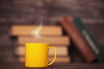 Books and cup of coffee on wooden background.