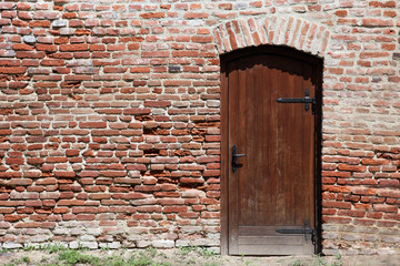 Old brown brick wall with a wooden door