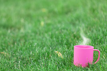 Obraz premium Cup of coffee on green grass