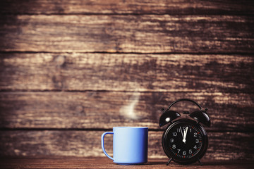 Tea or coffee cup and alarm clock