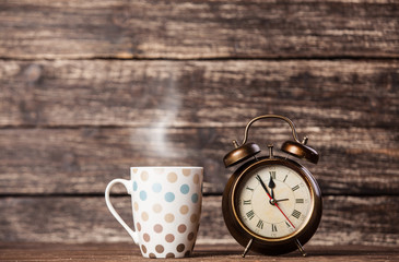 Tea or coffee cup and alarm clock