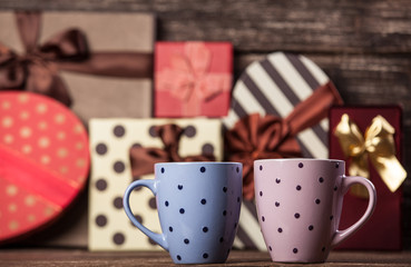 Two cup of coffee and holidays gifts on background.