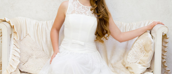 Fototapeta na wymiar Woman in a white dress on a white sofa