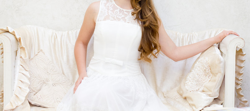 Woman in a white dress on a white sofa