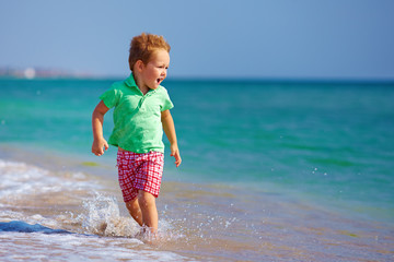 Fototapeta na wymiar cute kid boy having fun on the sea beach
