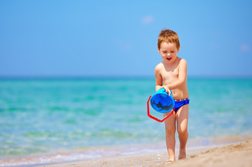 happy boy playing with toys on the beach