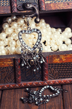 vintage earrings in a form of hearts hanging on old treasure che