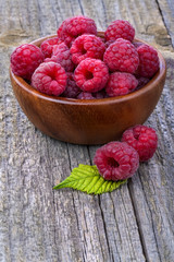 Healthy organic raspberries in a bowl on the old rustic table