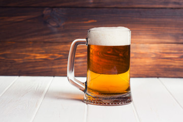 Mug of beer on wooden background
