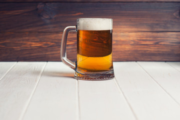 Mug of beer on wooden background