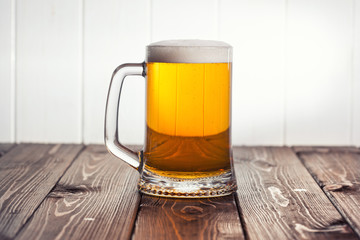 Mug of beer on wooden background