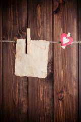 old paper sheet and small paper heart hanging on clothesline aga
