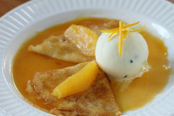 Pancakes crepes with ice cream and orange sauce