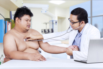 Doctor is checking a fat man