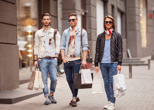 Three Young male fashion metraseksuals shop shopping walk