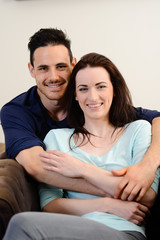 Fototapeta premium happy beautiful young couple relaxing sofa together home