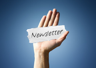 Man holding a scrap of paper with - Newsletter