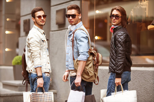Three Young male fashion metraseksuals shop shopping walk