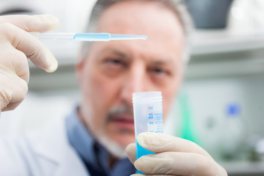 Close-up portrait of a male researcher filling a test tube