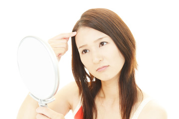 顔のシミを気にする女性