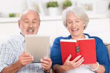 älteres paar mit buch und e-book