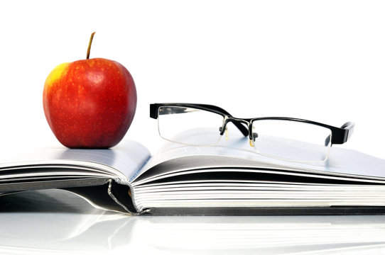 Offenes Buch mit Apfel und Nerd Brille