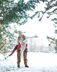 Mann trägt Frau huckepack im Winter