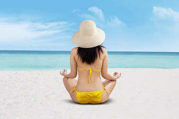 Fototapeta na wymiar Young beautiful woman meditation on beach