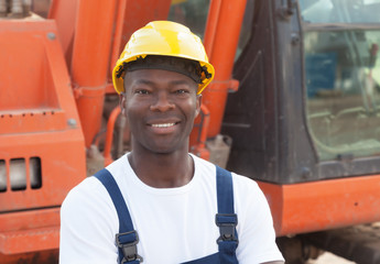 Laughing african construction worker with red excavator