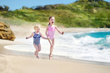 Naklejka premium Two little sisters having fun on a beach
