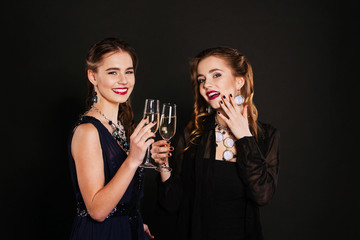 Two young beautiful women friends standing together and having