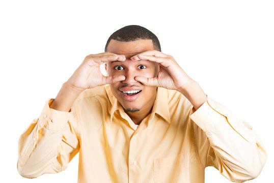 Man looking through binoculars spying surprised face expression