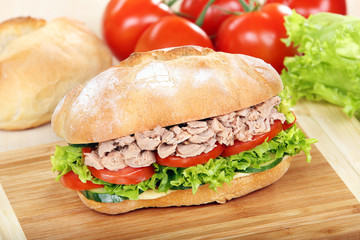 Sandwich with tuna on wood background