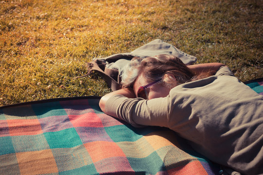 Woman relaxing on blanket at sunset