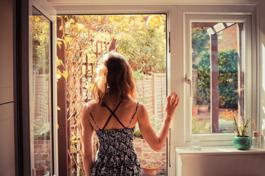 Woman standing in doorway at sunrise
