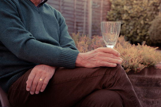 Senior man drinking wine in garden