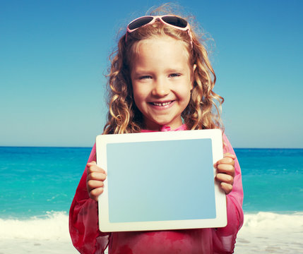 Child On The Beach With Tablet  Pc