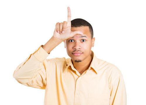 Portrait young man giving loser sign isolated white background 