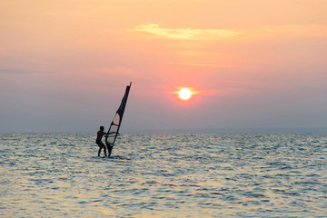 windsurfer silhouette against sunset background