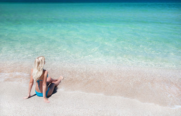 Fototapeta na wymiar beautiful slender young woman on the sea beach