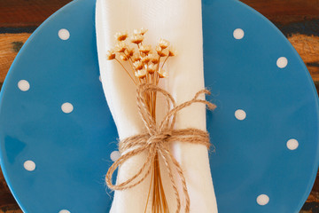 Blue plate white serviette flowers. Selective focus