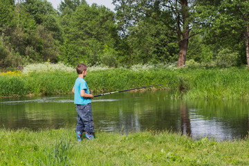 Fototapeta na wymiar boy with a fishing rod on the river bank