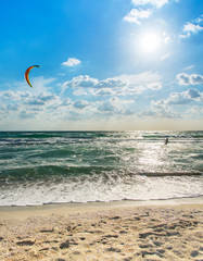 Kitesurfing. Kitesurfer rides the waves against sky