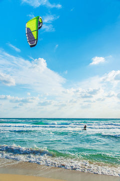 Kitesurfing. Kitesurfer rides the waves against sky